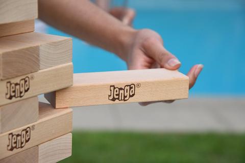 someone pulling out a giant jenga block - Bachelorette Party Activities for the Casual Bride 